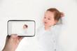 © New Africa - Young woman holding CCTV monitor and looking at child, top view with space for text