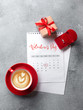 Valentine's Day greeting card. Red coffee cup, ring and gift box over february calendar. View from above