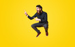 canvas print picture - Portrait of bearded man screaming and jumping over yellow background and pointing away