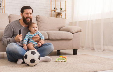 Wall Mural - Dad and his son watching football at home