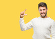 © Krakenimages.com - Young handsome man wearing winter sweater over isolated background smiling and confident gesturing with hand doing size sign with fingers while looking and the camera. Measure concept.