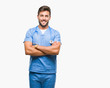 © Krakenimages.com - Young handsome doctor nurse man over isolated background happy face smiling with crossed arms looking at the camera. Positive person.