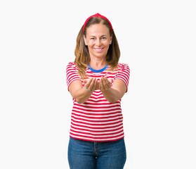 Wall Mural - Beautiful middle age woman wearing casual stripes t-shirt over isolated background Smiling with hands palms together receiving or giving gesture. Hold and protection