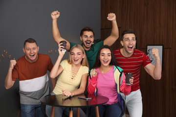 Wall Mural - Group of friends celebrating victory at home