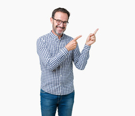 Canvas Print - Handsome middle age elegant senior business man wearing glasses over isolated background smiling and looking at the camera pointing with two hands and fingers to the side.