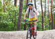 © Natali - Child teenager on  bicycle ride in  forest at spring or summer. Happy smiling Boy cycling outdoors in blue helmet. Active lifestyle, hobby