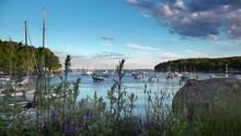 Peaceful New England Harbor In Summer With Boats At Anchor And Blue Skies And Wetlands Grasses In The Foreground