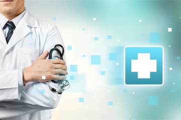 Wall Mural - Male doctor with stethoscope on blurred hospital background