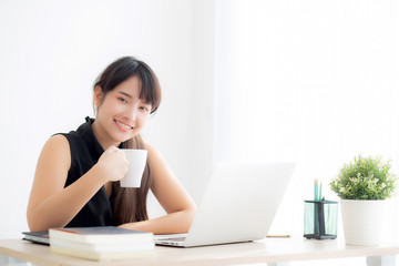 Beautiful young freelance asian woman smiling working and on laptop computer at desk office with professional, girl using notebook and drink coffee, business and lifestyle concept.