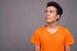 © Ranta Images - Portrait of young Asian man against gray background