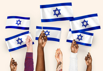 Wall Mural - Hands waving flags of Israel