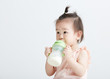 © lichaoshu - Cute Asian girl drinking milk with a bottle. On white background