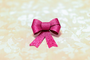 Isolated Red Christmas bow on a table with textured background