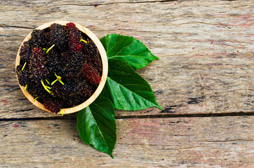 Wall Mural - Mulberries organic fruits in wooden bowl on old wood backgrounds above