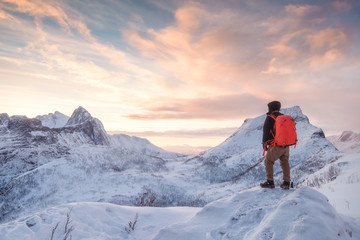 Wall Mural - Tourist man climbs on top snowy mountain