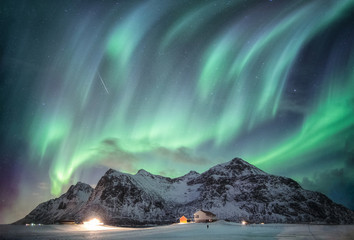 Wall Mural - aurora borealis with starry over snow mountain range with illumination house in flakstad, lofoten is