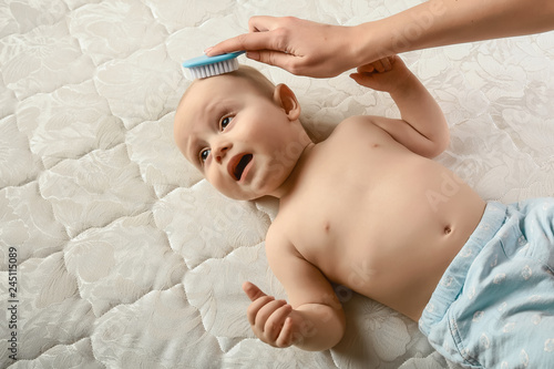 Mother Combing Hair For Her Infant Baby Boy Concept Of Newborn