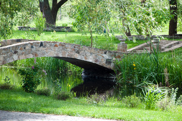 In harmony with nature. Landscape park. Stone bridge on summer landscape. Old stone bridge in botanical garden. Landscape architecture and landscaping. Summer vacation and wanderlust