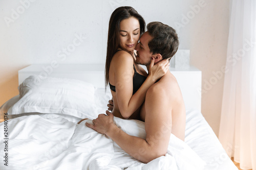 Lovely Couple 30s Making Love While Lying In Bed At Home Or