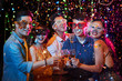 © DragonImages - Happy excited young Vietnamese people in party glasses posing with champagne glasses under fallling confetti