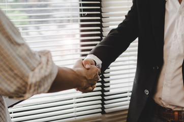 Wall Mural - Deal - close up hand of two business people shaking hands after successful job interview in modern meeting room at office, home loan contract, partnership, teamwork and business contract concept