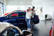 © hedgehog94 - Beautiful young couple at car showroom choosing a new car to buy.