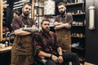 Hipster young good looking man at barber shop and hairstylist. Trendy and stylish beard styling and hair cut.