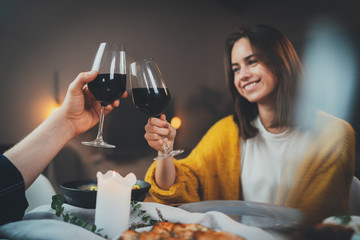 Wall Mural - Beautiful couple enjoying dinner at home, concept love relationship and romantic, happy couple celebrating and making cheers with glasses of red wine