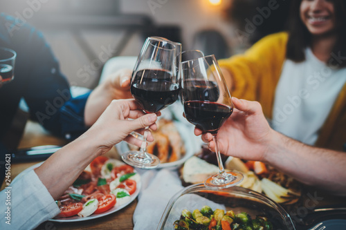 Say Cheers! Group of young people cheering with wine glasses during celebrate birthday in restaurant, Friendship Dinner Holidays Concept, best friends enjoying dinner at home