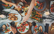 © iana_kolesnikova - Top view shot of group of people enjoying healthy food and toasting at home, togetherness and friendship concept, filtered image, family dinner at home