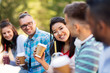 © Syda Productions - people, friendship and international concept - group of happy friends drinking coffee and juice talking in city