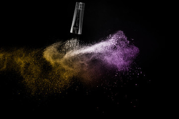 gold and purple powder splash and brush for makeup artist or beauty blogger in black background