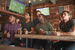 © Monkey Business - Group Of Male Friends Watching Game On Screen In Sports Bar