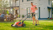 © Gorodenkoff - Good Father Teaches Son How to Use Walk Behind Lawn Mower, They Push it Together, Cutting Grass. Family Spending Time Together on a Sunny Day.