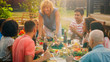 © Gorodenkoff - At the Family Garden Party, Mother Brings Dish with Roasted Bird and Puts it on the Table. Family and Friends Gathered together at the Big Table. Eating, Drinking and Having Fun.