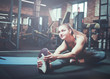 © splitov27 - Training and sport concept, woman stretching leg at gym