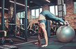 © splitov27 - Balance, strength concept.Sporty woman do handstand with legs on fit ball. Girl in sportswear training on fitball in gym. Sport, fitness training