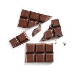 Wall Mural - Pieces of tasty black chocolate on white background, top view