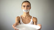 Slim girl with taped mouth showing empty plate, severe diet and self-destruction