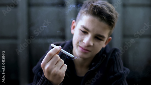 Fotografía Bad company and street influence, boy smoking cigarette, childrens protest