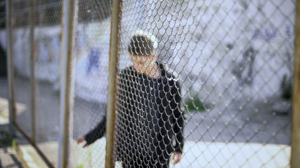 teen boy behind fence confinement, boarding school restrictions, broken future