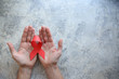 © dyageleva - man's hands hold a red ribbon.hiv awareness concept, world AIDS day