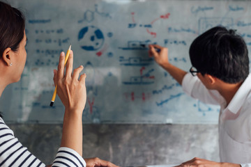 Wall Mural - high school or college student group catching up workbook and learning tutoring in classroom and rea