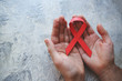© dyageleva - man's hands hold a red ribbon.hiv awareness concept, world AIDS day