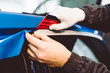 © hedgehog94 - Car wrapping specialist putting vinyl foil or film on car. Selective focus.