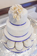 canvas print picture - Wedding cake with ice and blue ribbon decoration and white roses on the top tier