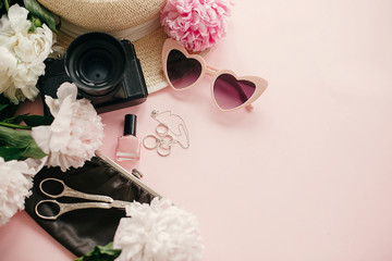 Wall Mural - Stylish girly flat lay with pink peonies, photo camera, retro sunglasses, jewelry, nail polish, hat, purse on pastel pink paper with copy space. International Women's Day. Hello spring