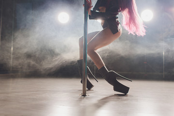 young striptease dancer moving in high heels shoes on stage in strip night club, Pole dancing.