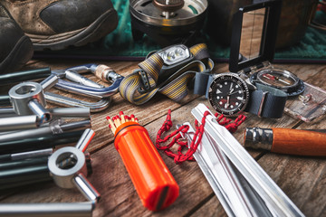 close up of wrist watch, compass, knife and other camping gear