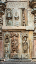 Belur, Karnataka, India - November 2, 2013: Chennakeshava Temple. Brown Wall Stone Panel Sculpture Of Lord Vishnu Surrouned By His Two Consorts Devi Lakshmi And Devi Bhu With Shilabalika Women. 